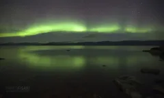 SVE1016_0243_Northern lights reflecting on still waters of lake Tometräsk in Abisko National Park (Sweden)